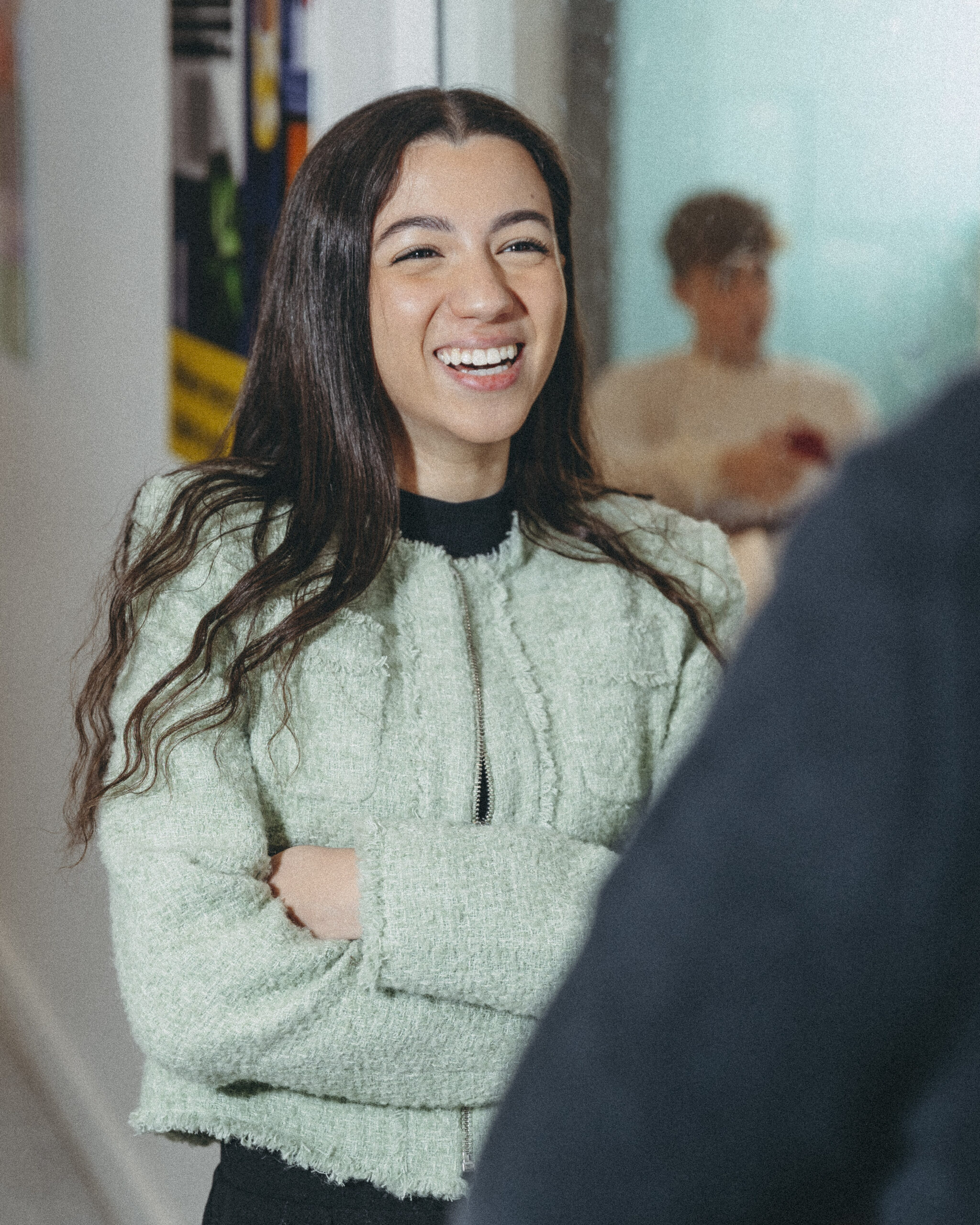 Elève souriant devant un enseignant dans un couloir